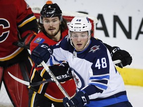 Winnipeg Jets' Brendan Lemieux, right, and Calgary Flames' Rasmus Andersson, of Sweden, struggle for position during preseason NHL hockey action in Calgary, Monday, Sept. 24, 2018.THE CANADIAN PRESS/Jeff McIntosh