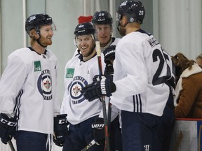 Winnipeg Jets' Kyle Connor (81), Bryan Little (18), Patrik Laine (29) and Blake Wheeler (26) joke around during on-ice testing on the first day of the Jets NHL training camp in Winnipeg, Friday, September 14, 2018. THE CANADIAN PRESS/John Woods ORG XMIT: JGW105