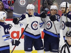 Winnipeg Jets Andrew Copp (9) celebrates his goal with teammates Josh Morrissey (44), Brandon Tanev (13) and Adam Lowry (17) during first period NHL hockey action against the Ottawa Senators at the Canadian Tire Centre in Ottawa on Monday, April 2, 2018. THE CANADIAN PRESS/ Patrick Doyle ORG XMIT: PD104