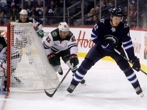 Winnipeg Jets' Kristian Vesalainen (42) carries the puck in front of Minnesota Wild's Justin Kloos (82) behind the Minnesota goal during second period preseason NHL hockey in Winnipeg, Monday, September 17, 2018. THE CANADIAN PRESS/Trevor Hagan ORG XMIT: WPGT125