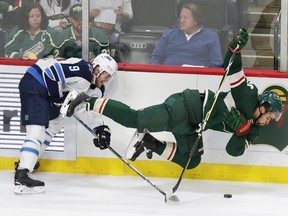 Jets’ Andrew Copp (left) upends Wild centre Jordan Greenway during the second period in St. Paul, Minn., last night.  AP