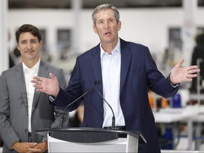 Prime Minister Justin Trudeau listens in as Manitoba Premier Brian Pallister speaks at a new 700 employee Canada Goose manufacturing facility in Winnipeg, Tuesday.