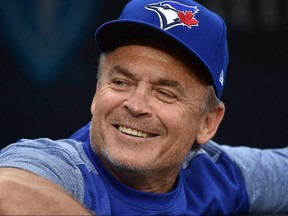 Blue Jays manager John Gibbons smiles from the dugout as he waits for a game to begin againts the Royals at Kauffman Stadium in Kansas City, Mo., Aug. 14, 2018.
