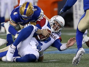 Montreal Alouettes QB Johnny Manziel is stopped on a run by Winnipeg Blue Bombers LB Adam Bighill (top) and Jovan Santos-Knox (bottom) Friday at Investors Group Field. (Kevin King/Winnipeg Sun)