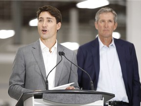 Manitoba premier Brian Pallister listens in as Prime Minister Justin Trudeau speaks during a press conference at a new 700 employee Canada Goose manufacturing facility in Winnipeg, Manitoba Tuesday, September 11, 2018.
