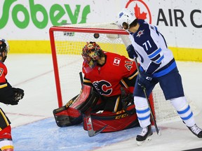 Calgary Flames’ Mike Smith gives up a goal to the Jets’ C.J. Suess at the Scotiabank Saddledome last night. (Al Charest/Postmedia)