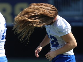 John Rush whips his hair before tying it off during Winnipeg Blue Bombers practice on Wed., Aug. 22, 2018. The fullback has been growing his hair for about four years, with the goal of donating it to a cancer patient in need while raising funds for breast cancer research and awareness. Kevin King/Winnipeg Sun/Postmedia Network