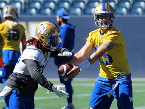 Matt Nichols (right) works the read-option play with Timothy Flanders during practice yesterday.  Kevin King/Winnipeg Sun