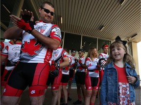 Hope Innis, 7, The Children's Wish Foundation Wish Child, is applauded by members of the Cops for Kids bicycle relay team at Winnipeg Police Service headquarters on Smith Street in Winnipeg on Monday before they head out on a fundraising cycle to Tucson, Ariz.