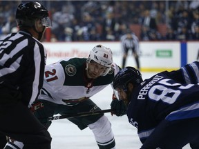 Minnesota Wild centre Eric Fehr (left) lines up in the face-off circle against Winnipeg Jets forward Mathieu Perreault during NHL preseason action in Winnipeg on Mon., Sept. 17, 2018. Kevin King/Winnipeg Sun/Postmedia Network