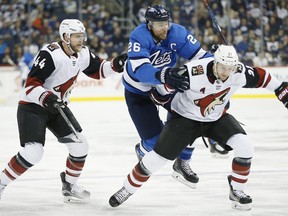 Jets’ Blake Wheeler (centre) tries to elude Arizona Coyotes’ Kevin Connauton (left) and Derek Stepan during Saturday's contest in Winnipeg. (JOHN WOODS/THE CANADIAN PRESS)