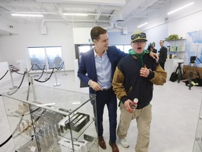 Steven Stairs, Canadian Cannabis activist and who camped overnight, reacts as John Arbuthnout, CEO of Delta 9 Cannabis escorts him to the sample counter to buy his first legal gram of marijuana in Winnipeg, Man., on Wednesday, October 17, 2018. Marijuana is now legal in Canada. THE CANADIAN PRESS/John Woods ORG XMIT: JGW106