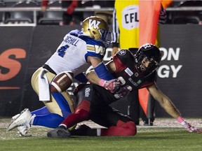 Winnipeg Blue Bombers linebacker Adam Bighill (4) knocks the ball loose from Ottawa Redblacks wide receiver Brad Sinopoli during overtime CFL action in Ottawa on Friday, Oct. 5, 2018. The Blue Bombers defeated the RedBlacks 40-32.