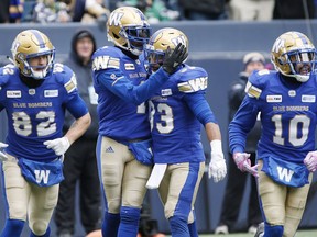 Winnipeg Blue Bombers' Darvin Adams (1) and Andrew Harris (33) celebrate Adams' touchdown against the Saskatchewan Roughriders during the first half of CFL action in Winnipeg Saturday, October 13, 2018.