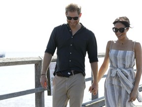 Britain's Prince Harry, left, and Meghan, Duchess of Sussex walk along Kingfisher Bay Jetty during a visit to Fraser Island, Australia, Monday, Oct. 22, 2018. Prince Harry and his wife Meghan are on day seven of their 16-day tour of Australia and the South Pacific.