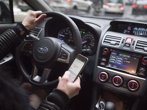 A driver texts while at the wheel in this photo illustration in Montreal on January 25, 2017. 237 Manitoba drivers were handed suspensions since stiffer penalties were put in place Nov. 1, 2018.