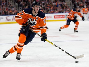 Vancouver Canucks' Erik Gudbranson (44) chases Edmonton Oilers' Connor McDavid (97) during second period pre-season action in Edmonton on Sept. 25, 2018.