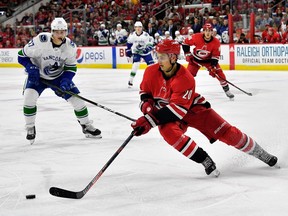 RALEIGH, NC - OCTOBER 09:  Sebastian Aho #20 of the Carolina Hurricanes moves the puck against the Vancouver Canucks during their game at PNC Arena on October 9, 2018 in Raleigh, North Carolina.
