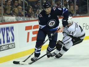 Winnipeg Jets defenceman Jacob Trouba (left) wheels away from Los Angeles Kings centre Nate Thompson in Winnipeg on Tues., Oct. 9, 2018. Kevin King/Winnipeg Sun/Postmedia Network