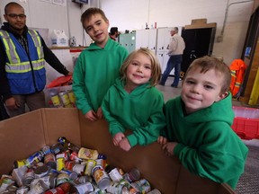 Maxwell Oliver (centre), along with sister Victoria and brother William, pose with some of the food his Cast-a-Can charity event outside the family's Riverview home raised for Winnipeg Harvest on Tues., Oct. 2, 2018. Kevin King/Winnipeg Sun/Postmedia Network