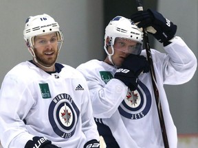 Bryan Little (left) and Nikolaj Ehlers hang out during Winnipeg Jets practice at Bell MTS Iceplex in Winnipeg on Monday.