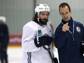 Mathieu Perreault (left) speaks with assistant coach Jamie Kompon during Winnipeg Jets practice at Bell MTS Iceplex in Winnipeg on Monday.