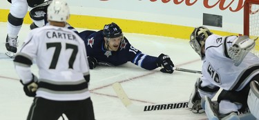 Winnipeg Jets centre Bryan Little stabs at the puck from his  belly after getting knocked down against the Los Angeles Kings in Winnipeg on Tues., Oct. 9, 2018. Kevin King/Winnipeg Sun/Postmedia Network