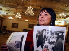 Shannon Dawn Marks holds up a newspaper article and a photo of herself, her mother, Joyce Linda Dwyar and her sister Cherrie Cassandra Costain after they were reunited 23 years after being taken from away from Dwyar by the federal government as part of the 'Sixties Scoop'. Marks and her mother were in Winnipeg this past weekend for the Manitoba Metis Federation's Sixties Scoop Symposium held at The Fort Garry Hotel.