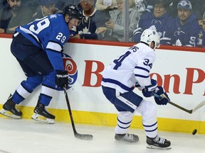 Winnipeg Jets forward Patrik Laine (left) turns the puck over to Toronto Maple Leafs centre Auston Matthews, leading to a goal from Kasperi Kapanen (not shown) in Winnipeg on Wed., Oct. 24, 2018. Kevin King/Winnipeg Sun/Postmedia Network