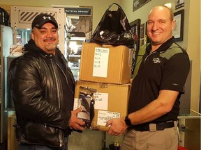 Winnipeg Bear Clan Patrol Executive Director James Favel (left) accepts donation of 100 pairs of protective safety gloves from Urban Tactical retail director Keith Ginther on Tuesday, Oct. 30, 2018. On the heels of that donation funding for the Bear Clan is coming from the province. File photo