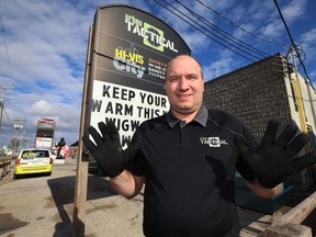 Keith Ginther, retail director for Urban Tactical, models a pair of protective gloves like the ones donated to Bear Clan Patrol, at their store on Century Street in Winnipeg, on Tuesday.