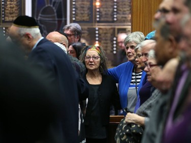 Attendees at a vigil for victims of a mass shooting on Saturday at a synagogue in Pittsburgh, stand joined together in prayer at Congregation Shaarey Zedek in Winnipeg, on Tues., Oct. 30, 2018. Kevin King/Winnipeg Sun/Postmedia Network