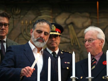 Rabbi Kliel Rose of Congregation Etz Chayim lights a candle at a vigil for victims of a mass shooting on Saturday at a synagogue in Pittsburgh, at Congregation Shaarey Zedek in Winnipeg, on Tues., Oct. 30, 2018. Kevin King/Winnipeg Sun/Postmedia Network