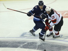 Winnipeg Jets centre Mark Scheifele (left) steps into New Jersey Devils forward Nico Hischier in NHL preseason action in Winnipeg on Thursday.