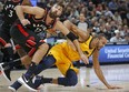 Toronto Raptors' Jonas Valanciunas pushes Utah Jazz centre Rudy Gobert to the floor as they battle under the basket during Monday's game. (AP PHOTO)
