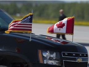 Canadian and United States flags are seen on a vehicle in the motorcade as President Donald Trump arrives at the airport at CFB Bagotville, Que. for the annual summit of G7 leaders on Friday, June 8, 2018. The event is being held in La Malbaie, in the Charlevoix region of Quebec.