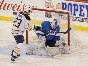 Winnipeg Jets goaltender Laurent Brossoit makes a save in front of Buffalo Sabres forward Sam Reinhart during Friday's game. (THE CANADIAN PRESS)