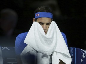 Roger Federer of Switzerland wipes his face with a towel during his ATP World Tour Finals singles tennis match against Alexander Zverev of Germany at the O2 Arena in London, Saturday Nov. 17, 2018.