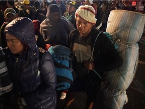 Central American migrants hoping to enter the U.S. wait to access a shelter in Tijuana, Mexico, Tuesday, Nov. 20. Immigration is one area where American and Canadian attitudes still differ sharply.