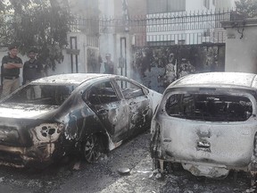 Pakistani security personnel stand next to burned out vehicles in front of the Chinese consulate after an attack in Karachi on Nov. 23, 2018.