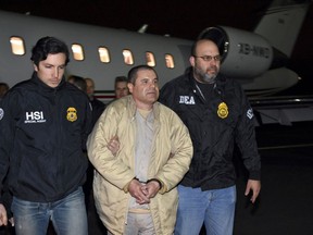 FILE - In this Jan. 19, 2017 file photo provided U.S. law enforcement, authorities escort Joaquin "El Chapo" Guzman, center, from a plane to a waiting caravan of SUVs at Long Island MacArthur Airport, in Ronkonkoma, N.Y. A jury has been picked for the U.S. trial of the Mexican drug lord. Seven women and five men were selected Wednesday, Nov. 7, 2018, as jurors in the case against Guzman. The trial is set to begin Nov. 13 with opening statements in federal court in Brooklyn. (U.S. law enforcement via AP, File)