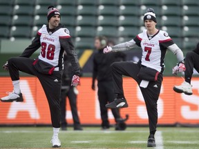 Redblacks quarterback Trevor Harris (7) and receiver Brad Sinopoli (88) participate in a stretching exercise during the team's walk-through at Commonwealth Stadium on Saturday.