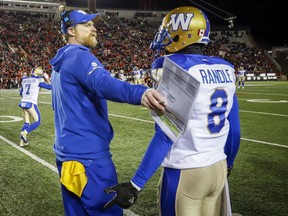 Winnipeg Blue Bombers head coach Mike O'Shea consoles Chris Randle, in the last seconds of the CFL West Final football game against the Calgary Stampeders in Calgary, Sunday
