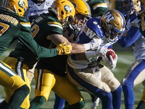 Winnipeg Blue Bombers Andrew Harris (33) is tackled by the Edmonton Eskimos during first half CFL action in Edmonton, Alta., on Saturday November 3, 2018. THE CANADIAN PRESS/Jason Franson ORG XMIT: EDM102