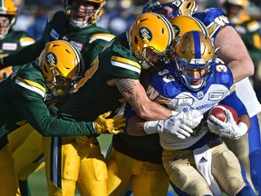 A team of Edmonton Eskimos wrap up Winnipeg Blue Bombers running back Andrew Harris (33) during CFL action in the last game of the season at Commonwealth Stadium in Edmonton, November 3, 2018. (Ed Kaiser/Postmedia Network)