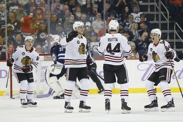 Chicago Blackhawks' John Hayden (40), Jan Rutta (44) and David Kampf (64) celebrate Rutta's goal against the Winnipeg Jets during second period NHL action in Winnipeg on Thursday, November 29, 2018. THE CANADIAN PRESS/John Woods