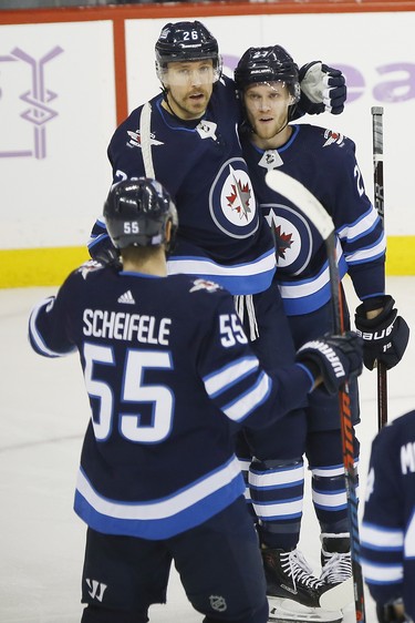 Winnipeg Jets' Blake Wheeler (26), Nikolaj Ehlers (27) and Mark Scheifele (55) celebrate Ehlers' goal against the Chicago Blackhawks during first period NHL action in Winnipeg on Thursday, November 29, 2018. THE CANADIAN PRESS/John Woods