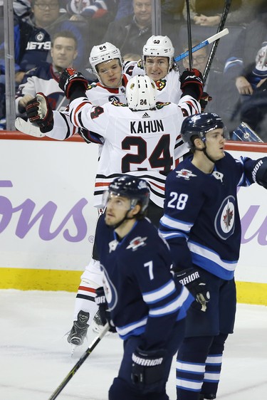 Chicago Blackhawks' David Kampf (64), Dominik Kahun (24) and John Hayden (40) celebrate Hayden's goal against the Winnipeg Jets during first period NHL action in Winnipeg on Thursday, November 29, 2018. THE CANADIAN PRESS/John Woods