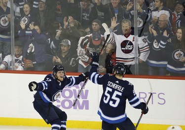 Winnipeg Jets' Nikolaj Ehlers (27) and Mark Scheifele (55) celebrate Ehlers' hat trick against the Chicago Blackhawks during third period NHL action in Winnipeg on Thursday, November 29, 2018. THE CANADIAN PRESS/John Woods