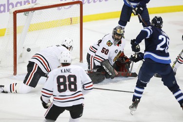 Winnipeg Jets' Patrik Laine (29) score his 20th goal of the season and his 100th career goal against Chicago Blackhawks goaltender Corey Crawford (50) during first period NHL action in Winnipeg on Thursday, November 29, 2018. THE CANADIAN PRESS/John Woods